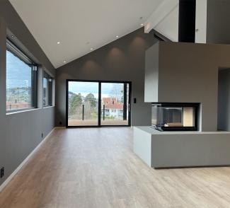 Stue i et nybygget hus med nytt gulv, uten møbler