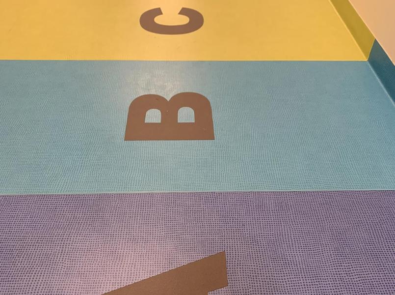 nærbilde av et gulv som er har delte felter med farger og bokstaver