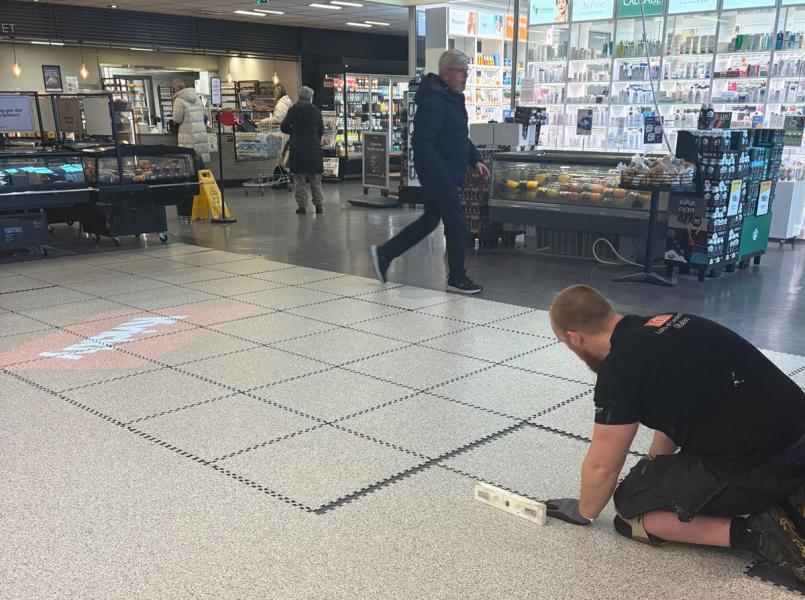Alt-tekst:  **Montering av lyst butikkgulv i Kvickly Helsinge mens butikken holder åpent for kunder.