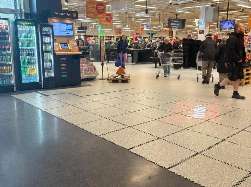 Etappevis gulvrenovering i Kvickly Helsinge med nytt lyst butikkgulv lagt i seksjoner mens kunder handler i butikken.