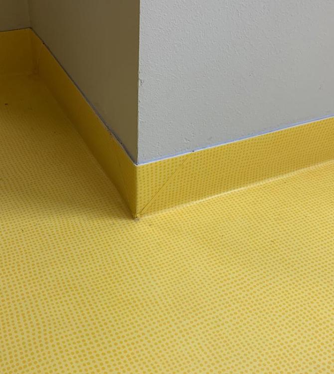 nærbilde av et hjørne med gulv og kantlist i samme farge