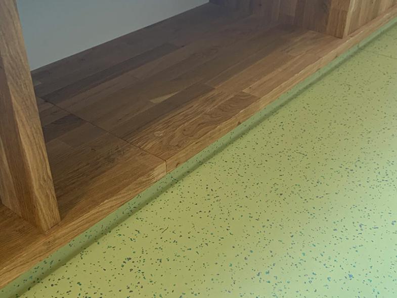 nærbilde av et grønt gulv og skohylle