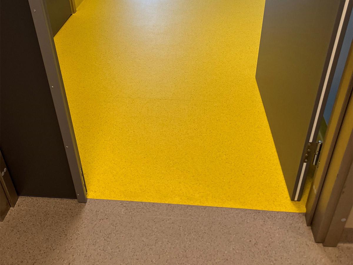 Nærbilde av et gult gulv i fellesareal på Nye Narvik Sykehus