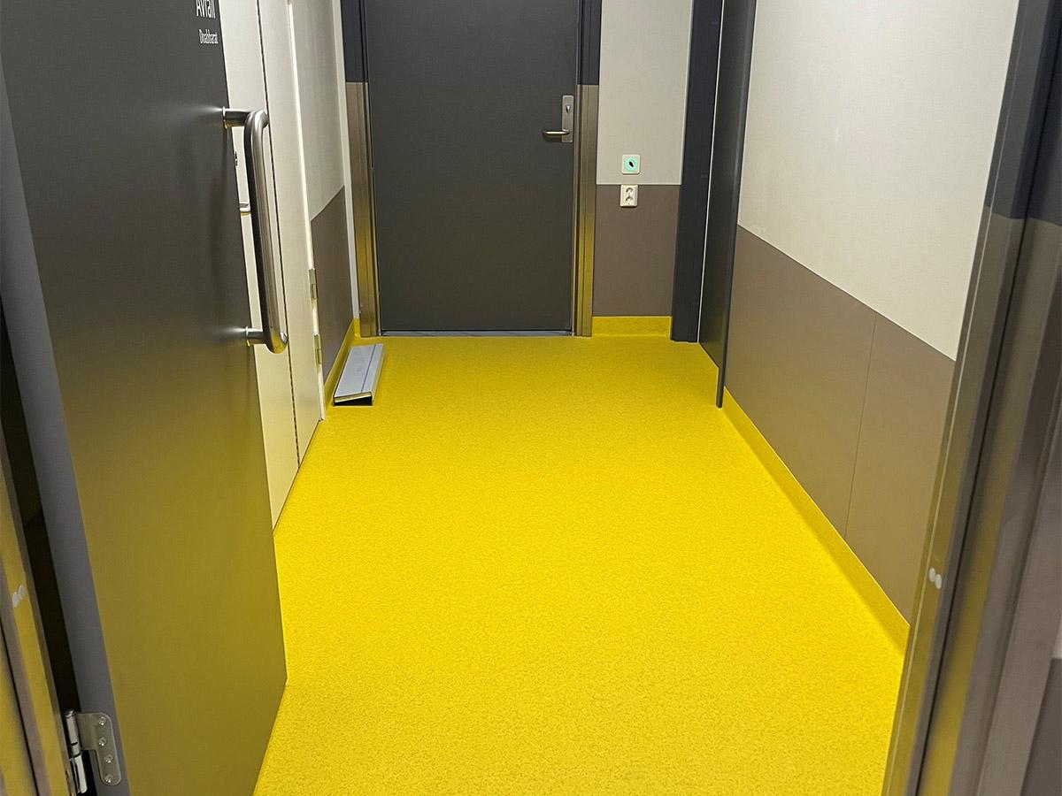 Nærbilde av gult gulv i fellesareal på Nye Narvik Sykehus