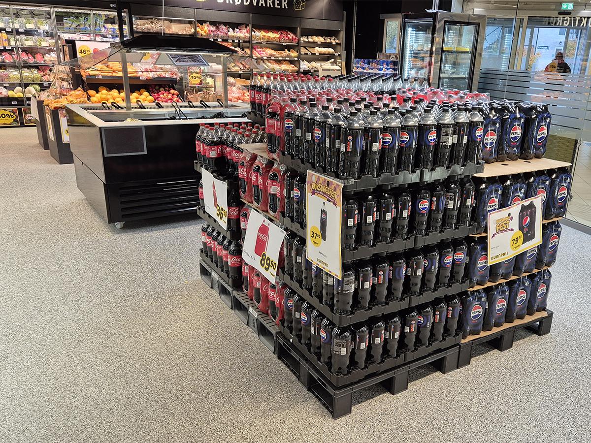 Bilde av butikkhyller og nytt gulv i en Bunnpris butikk på Fauske. Pall med brus i forkant.