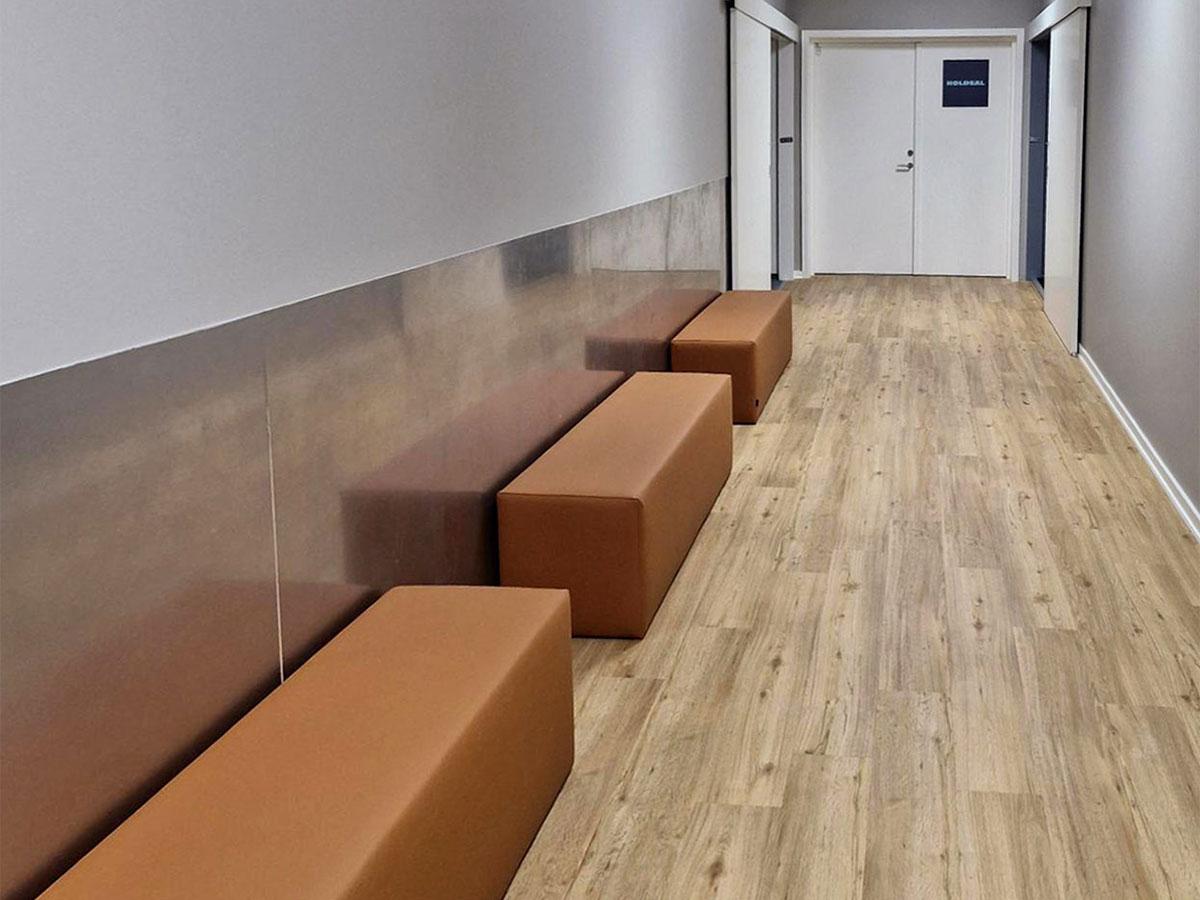 Bilde av gangen på et treningssenter med nytt gulv, sittebenker i skinn til venstre