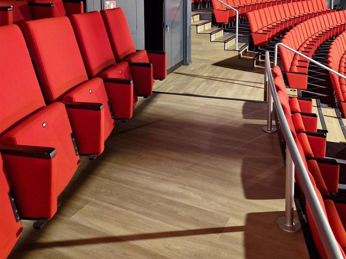 Nærbilde av sitteplasser i et teater med nytt gulv