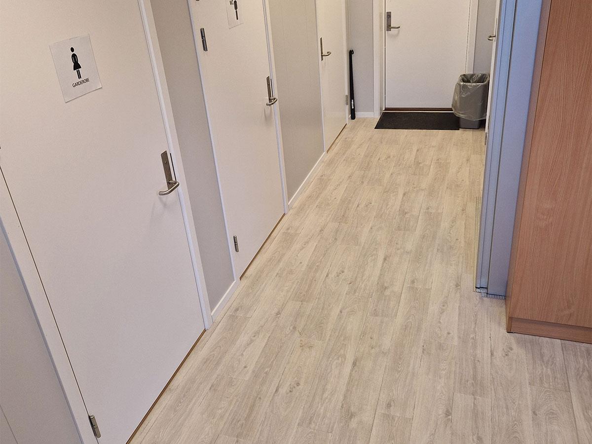 Nærbilde av nytt gulv i gangen på et kontor, trapp til høyre