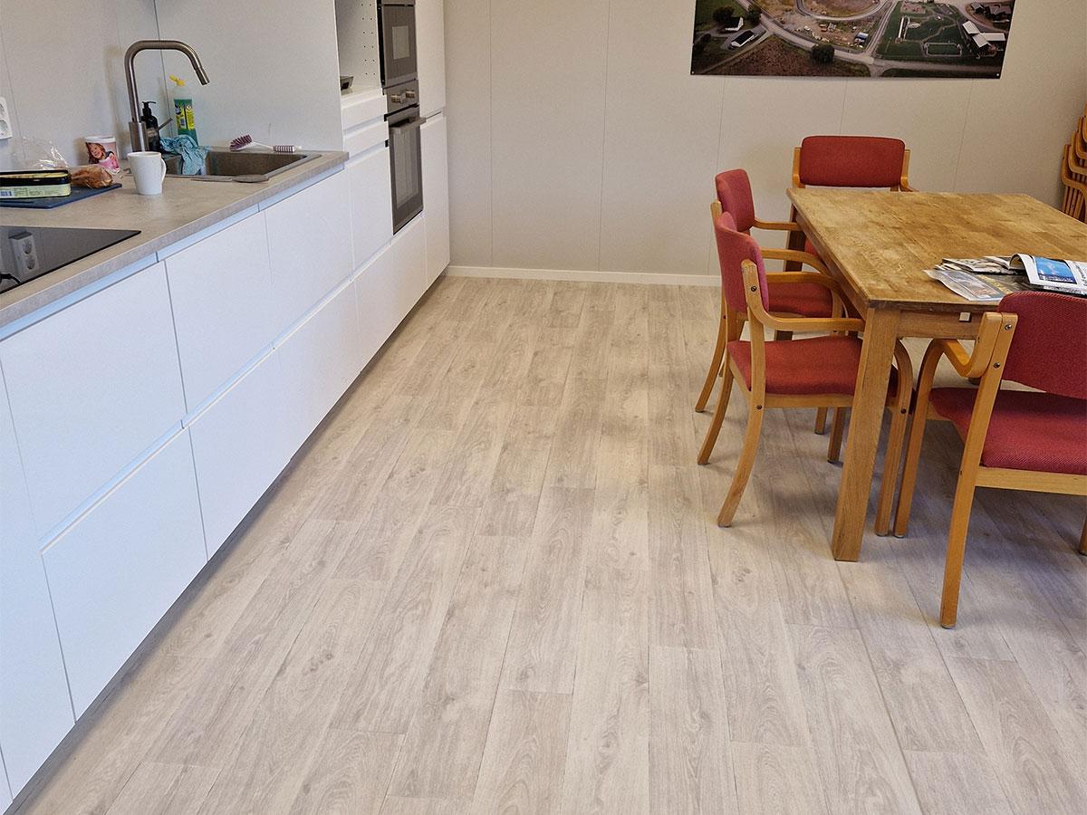 Nærbilde av nytt gulv på spiserommet i et kontor, kjøkkenbenk til venstre