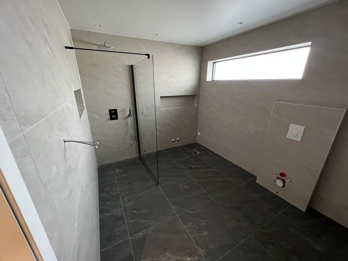 Baderom med dusj i et nybygget hus med nytt gulv, uten møbler 