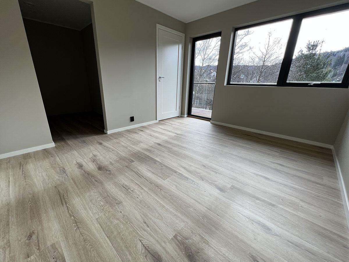 Soverom i et nybygget hus med nytt gulv, uten møbler 