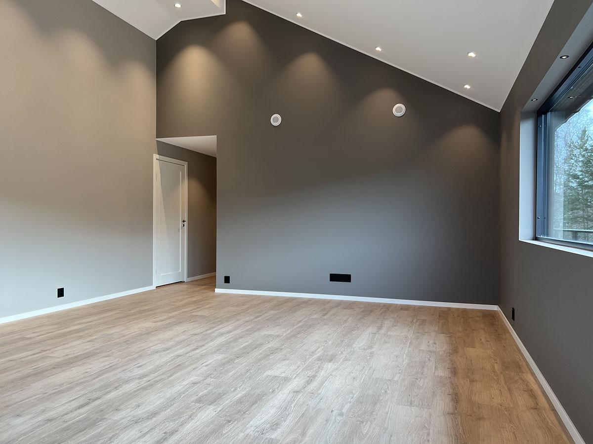 Stue i et nybygget hus med nytt gulv, uten møbler 