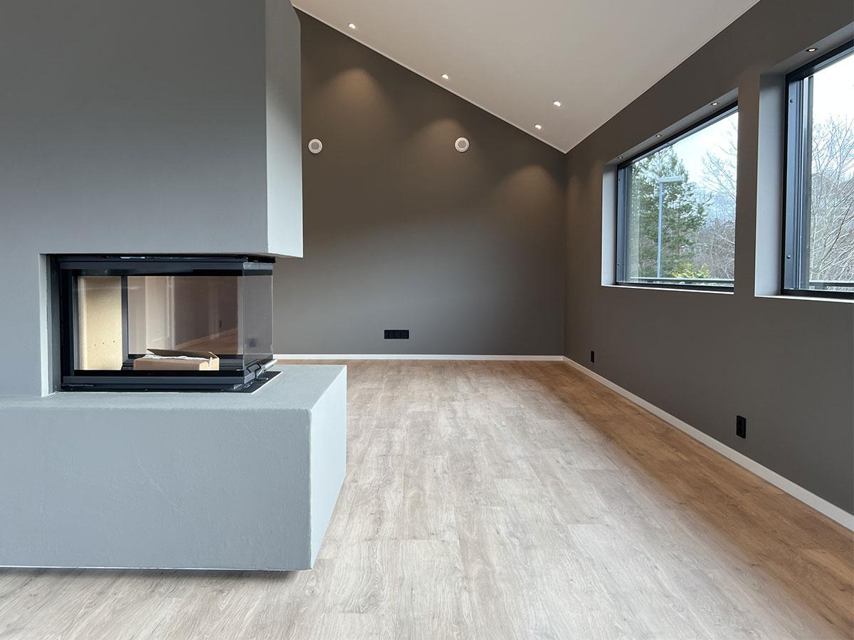 Stue i et nybygget hus med nytt gulv, uten møbler 