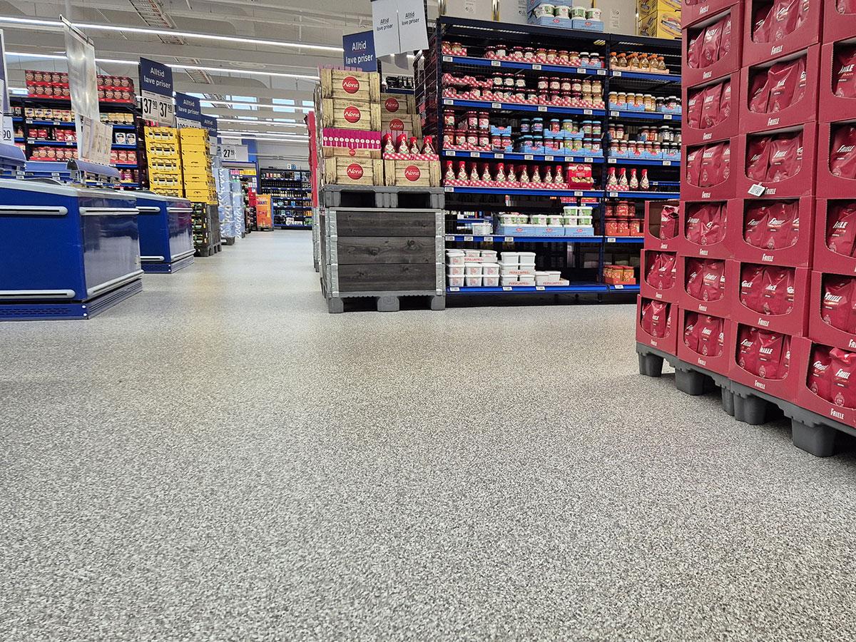 bilde fra en butikk som viser mye gulv i midten, butikkhyller til høyre og frysedisk til venstre