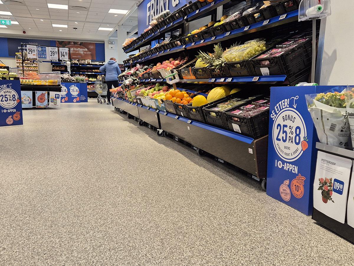 bilde av gulvet i en rema 1000 butikk med frukthylle til høyre