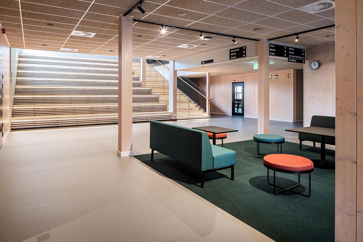 Fellesområde på en skole med sittegruppe i forkant og trapp opp i bakgrunnen