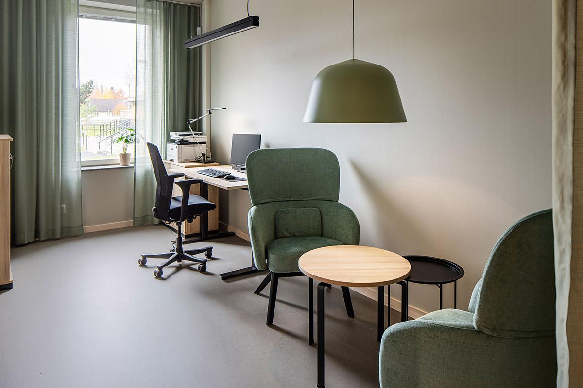 studenthybel med sittegruppe i forkant og skrivebord og stol i bakgrunnen