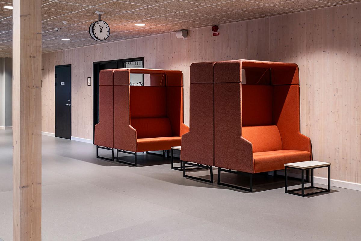 to sittebenker utformet som en boks i orange stoff med bord foran