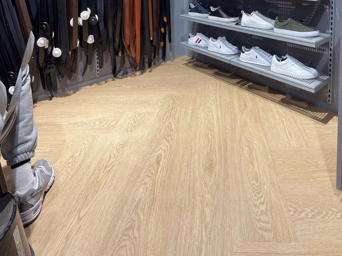 gulvbilde fra en klesbutikk hvor man så vidt ser hyller med klær øverst i bildet