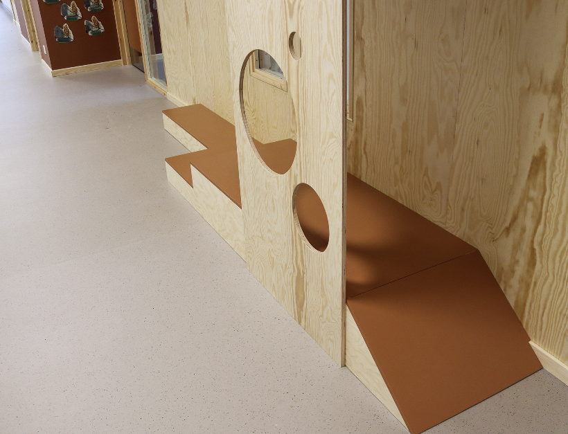 et lekestativ bygget i tre sett ovenfra plassert inntil veggen i en abrnehage