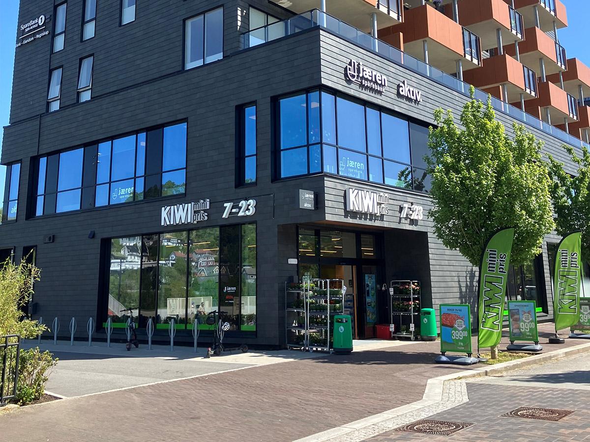 hjørnet av et mørkt bygg som viser inngangen til en kiwi butikk