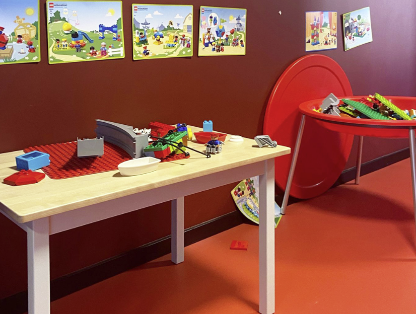 et bord med lego plassert inntil veggen i en barnehage
