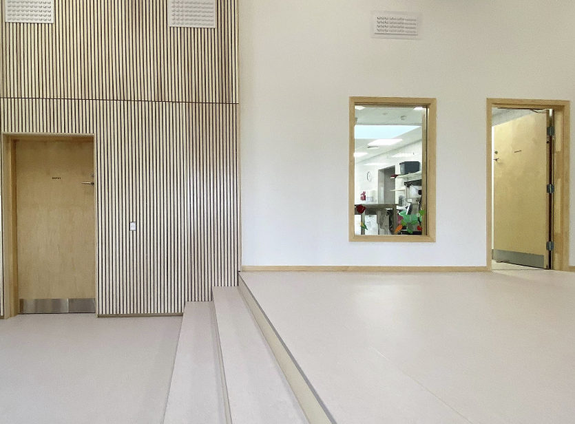 fellesområdet i en barnehage hvor man ser en liten trapp som siller de to sonene og nivåene