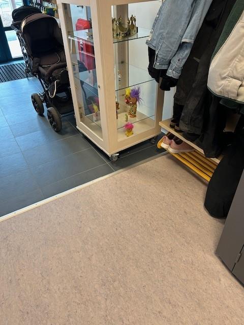 nærbilde av kille mellom fliser og gulv i en gang i en barnehage