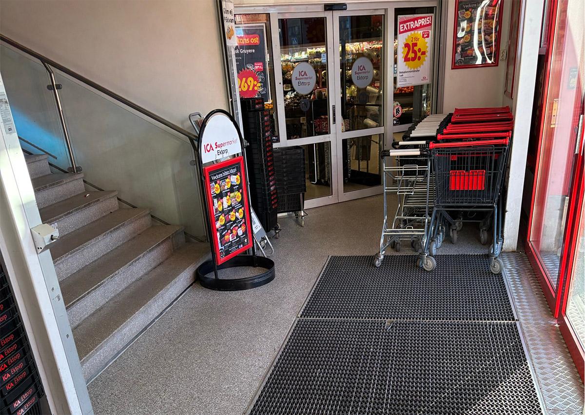inngangspartiet til ICA Ektorp. Skyvedører til butikken til høyre, trapp opp til venstre og en gatebukk i midten
