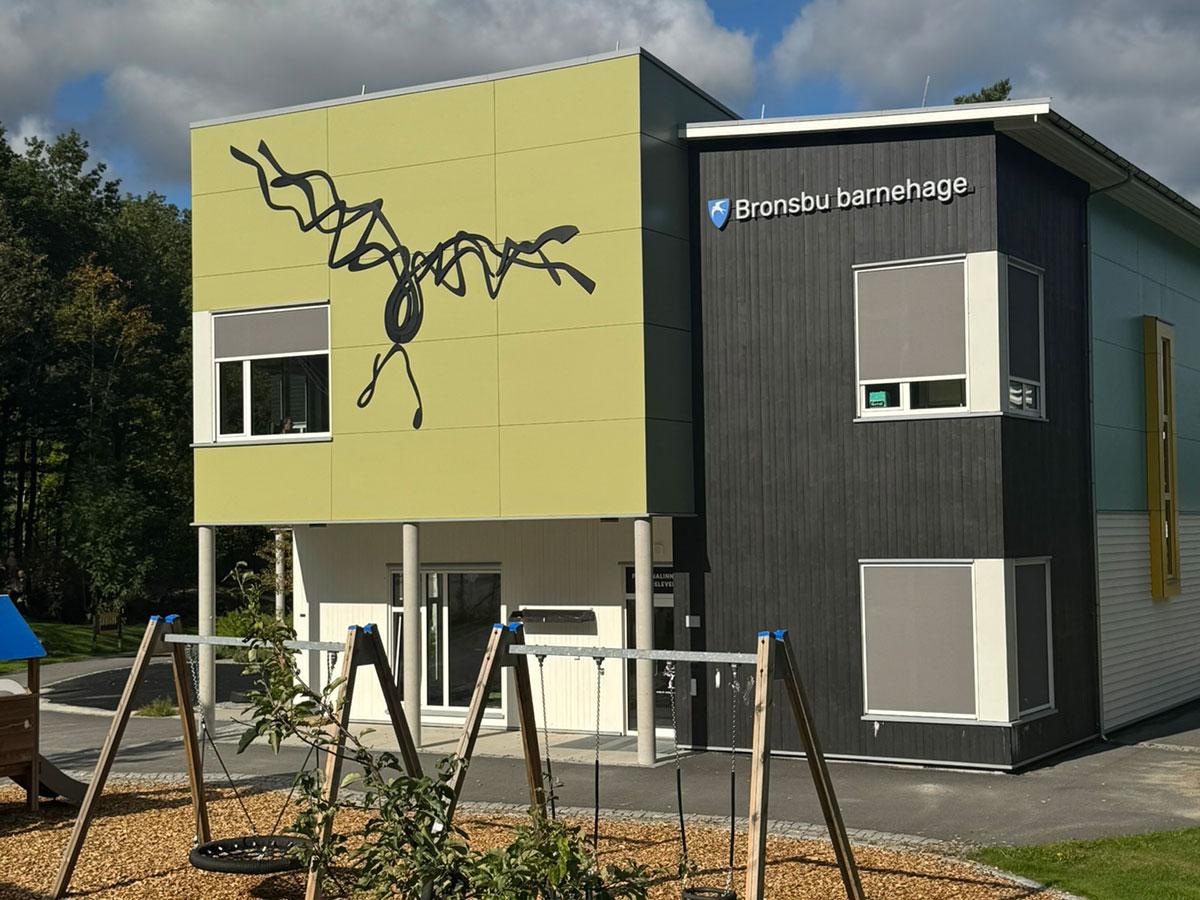 Bronsbu Barnehage bygget sett utenfra med huskestativer i forgrunnen