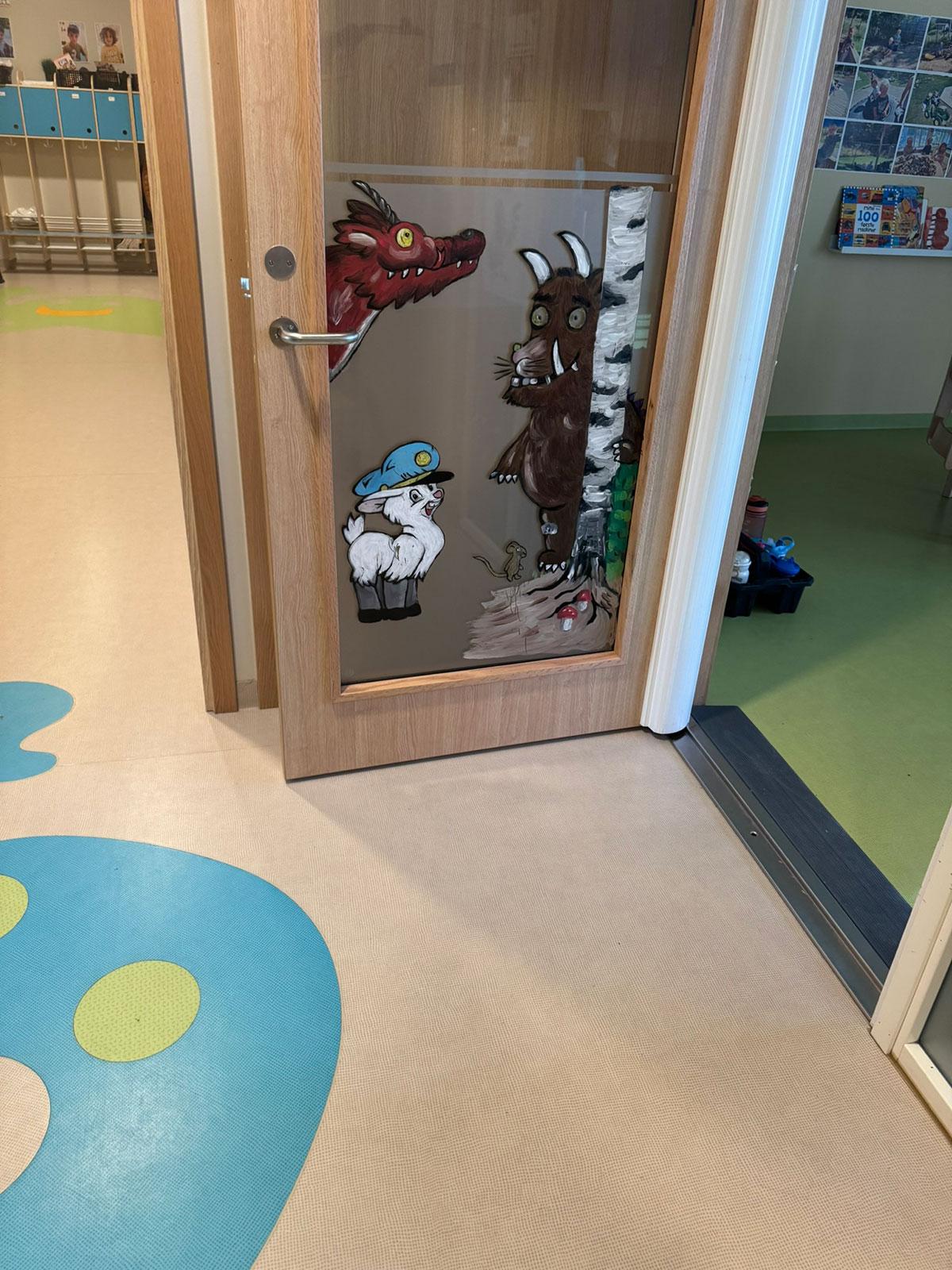 åpen glassdør mellom to rom som har ulik farge på gulvet. Til venstre kan man skimte en blå spøkelsesfigur i gulvet