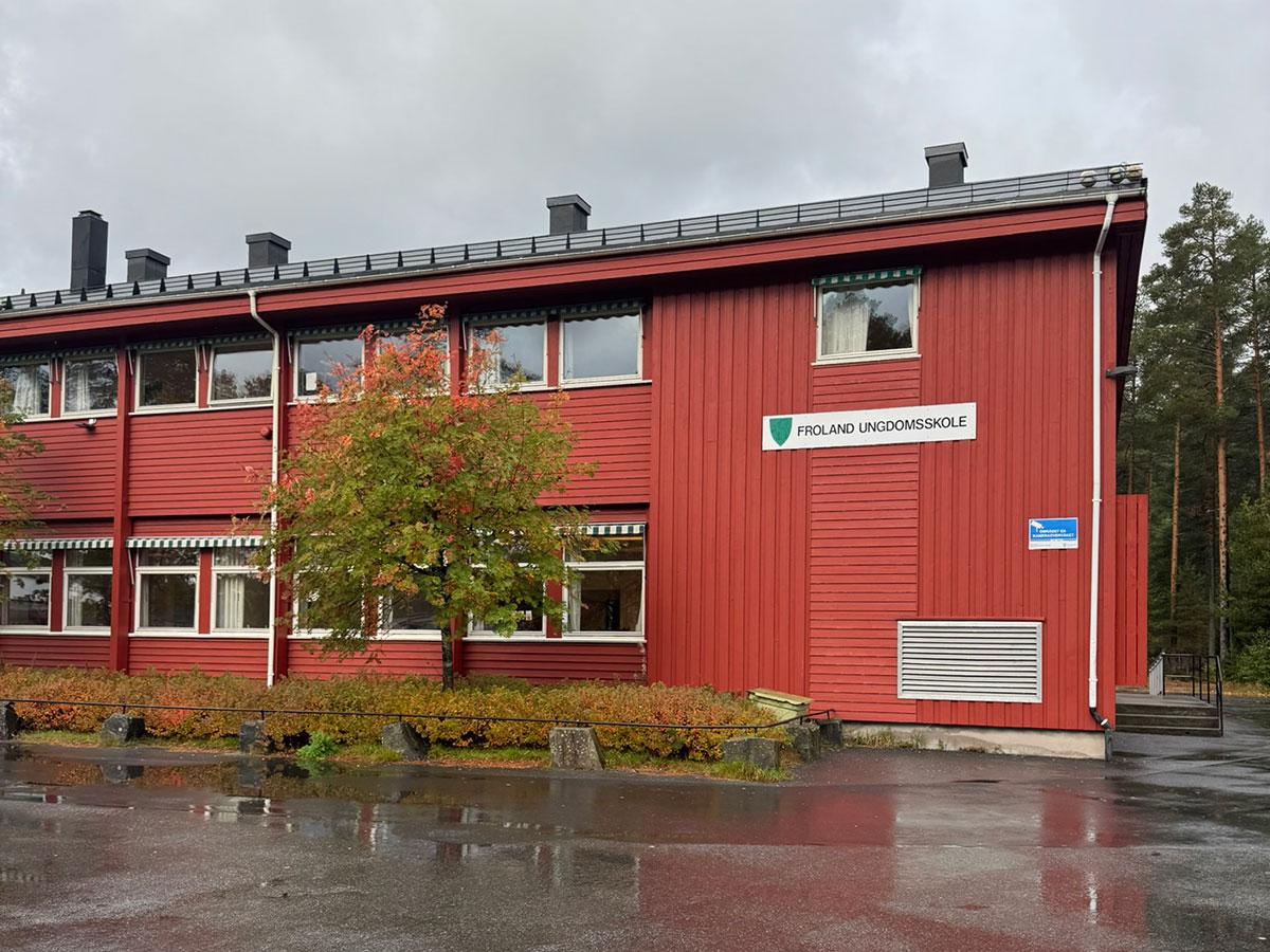 Froland Ungdomsskole fra utsiden. Ett rødt trebygg