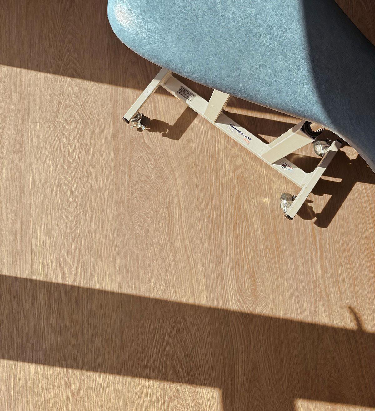 et lite utsnitt av en treningsbenk sett ovenfra. største delen av bildet viser et tregulv