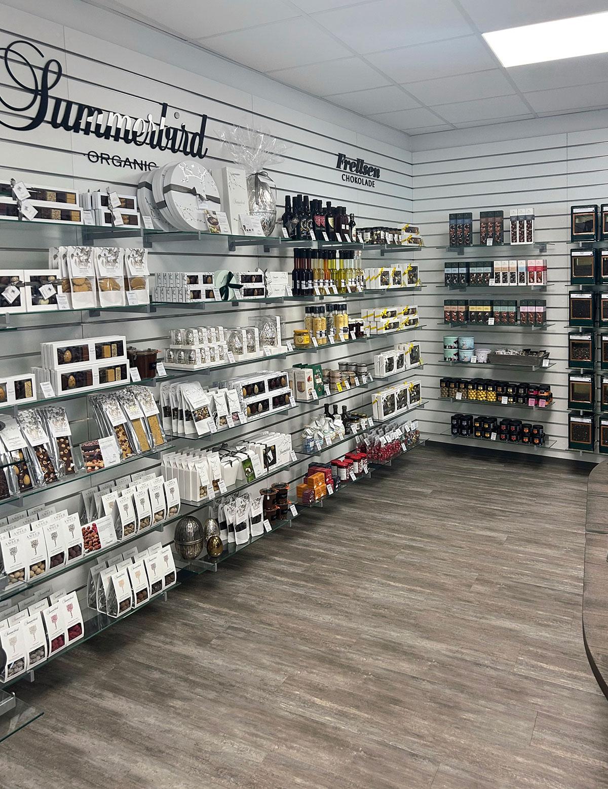 butikk med hvite vegger og butikkhyller langs hele veggen til venstre