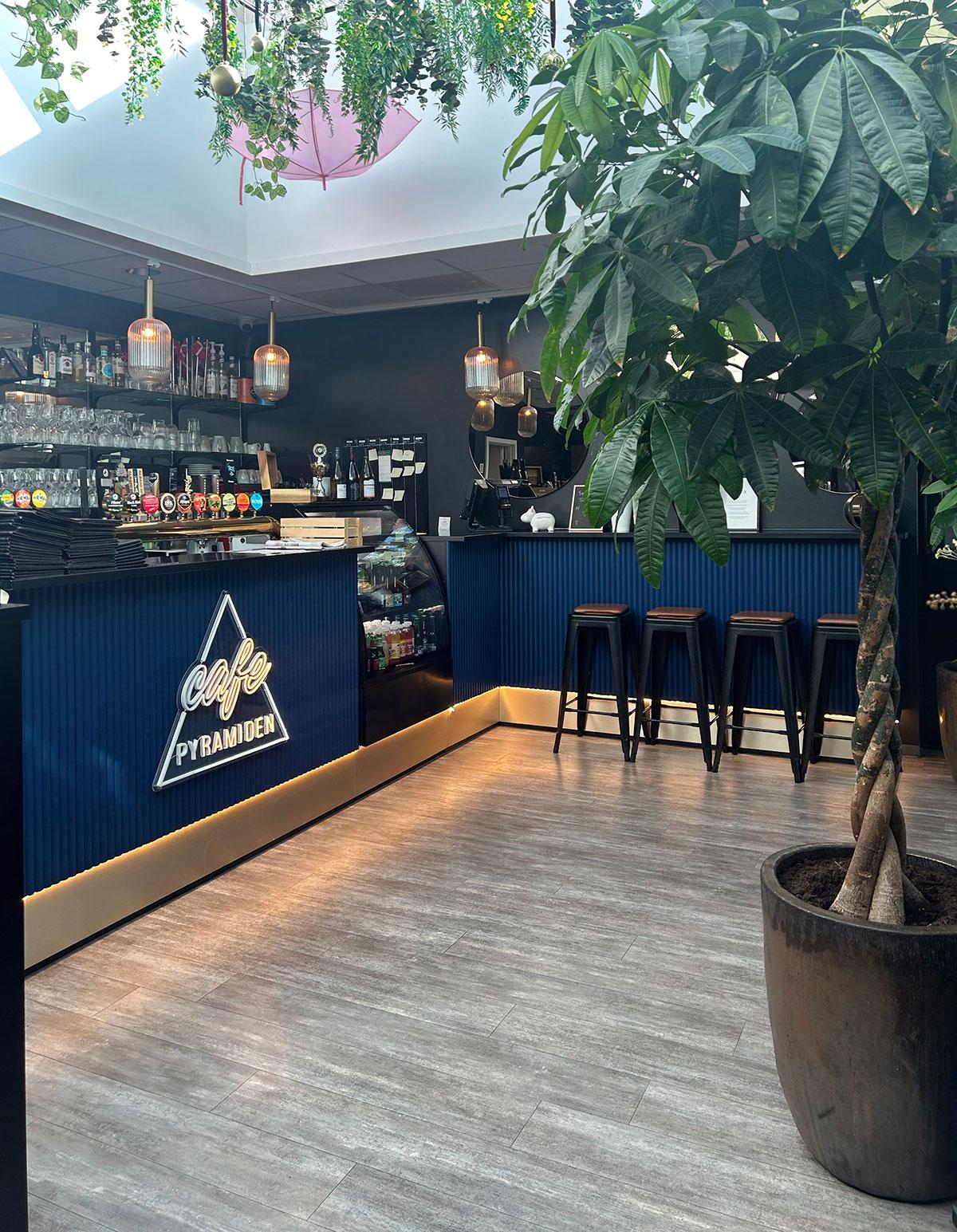 disken i en kafe med blå fronter og et lysskilt under disken. 