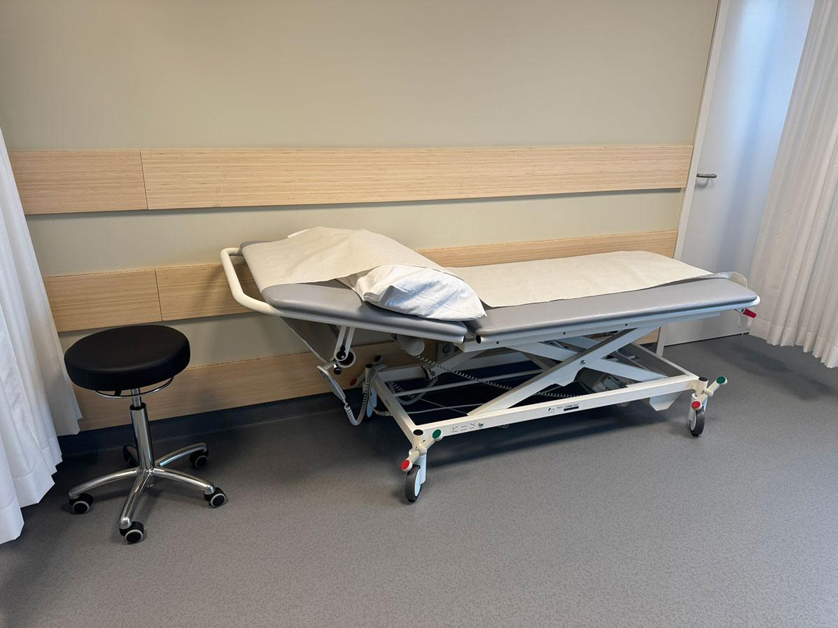 et behandlingsrom med sykeseng stående inntil vegg