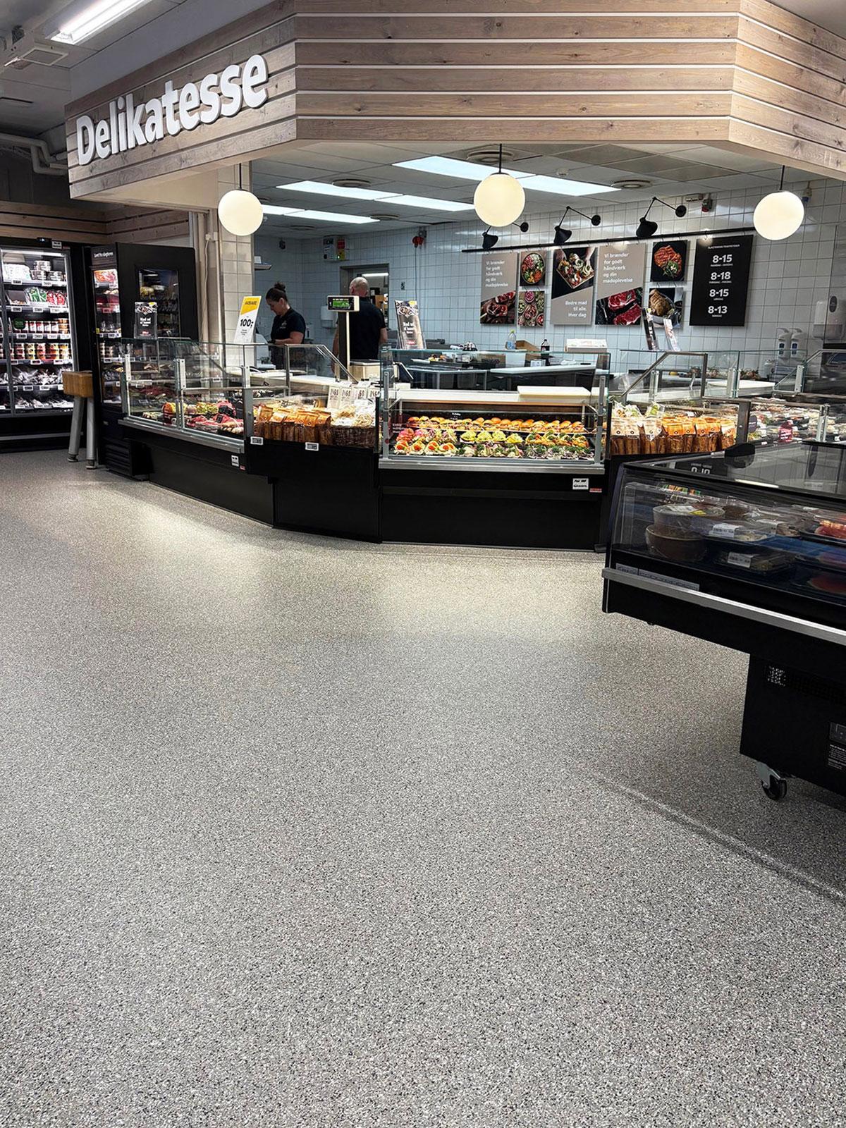 ferskvaredisken i en butikk med to butikkansatte bak disken