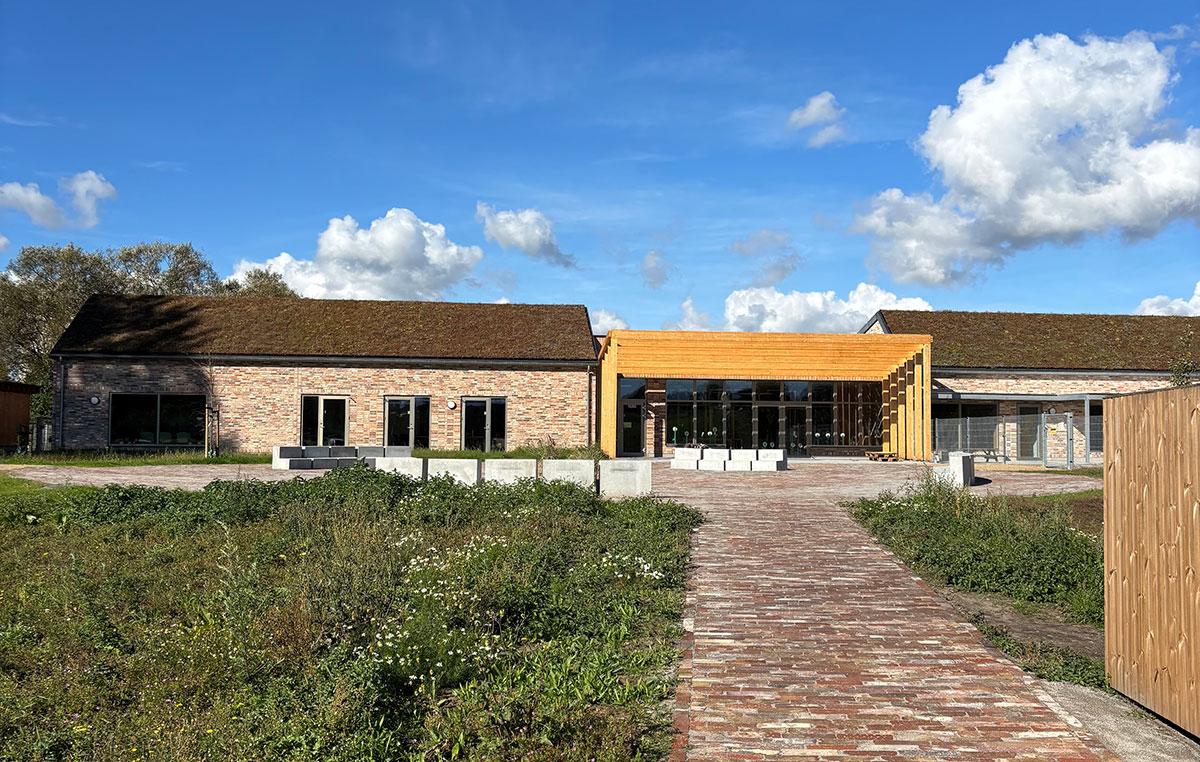 fasaden til et barnehjem hvor byggene til høyre og venstre for inngangen er utformet med teglstein