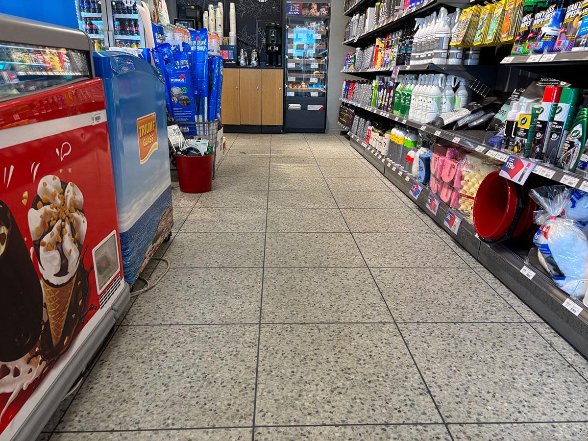 nærbilde av gulvet mellom hyllene i en bensinstasjon