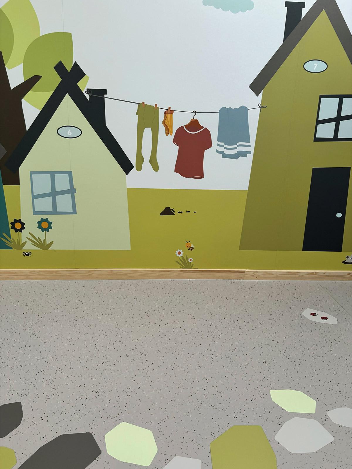 vegg dekorert med tegninger av hus i ulike farger og former