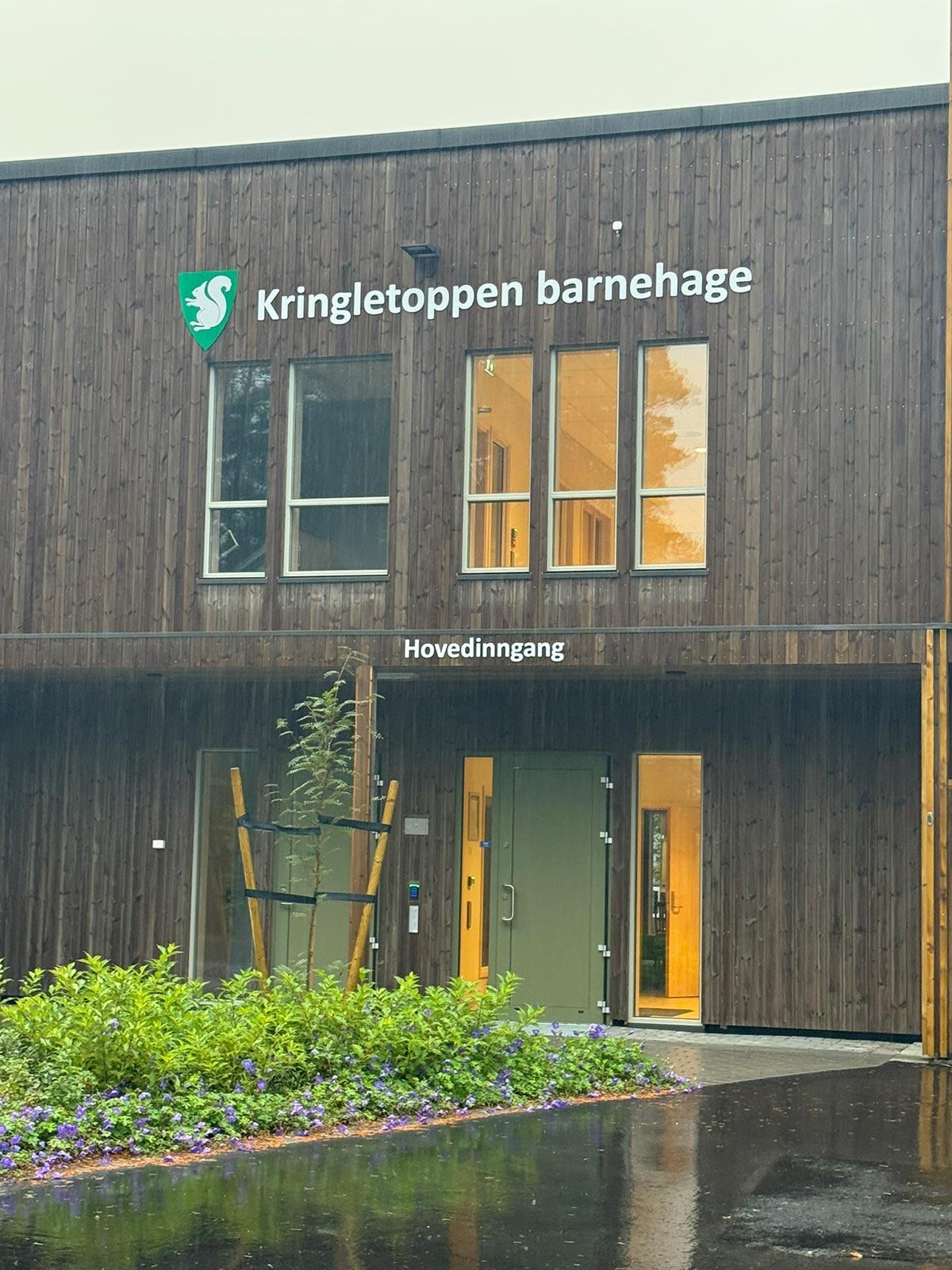 fasade i treverk med inngangen til Kringletoppen Barnehage