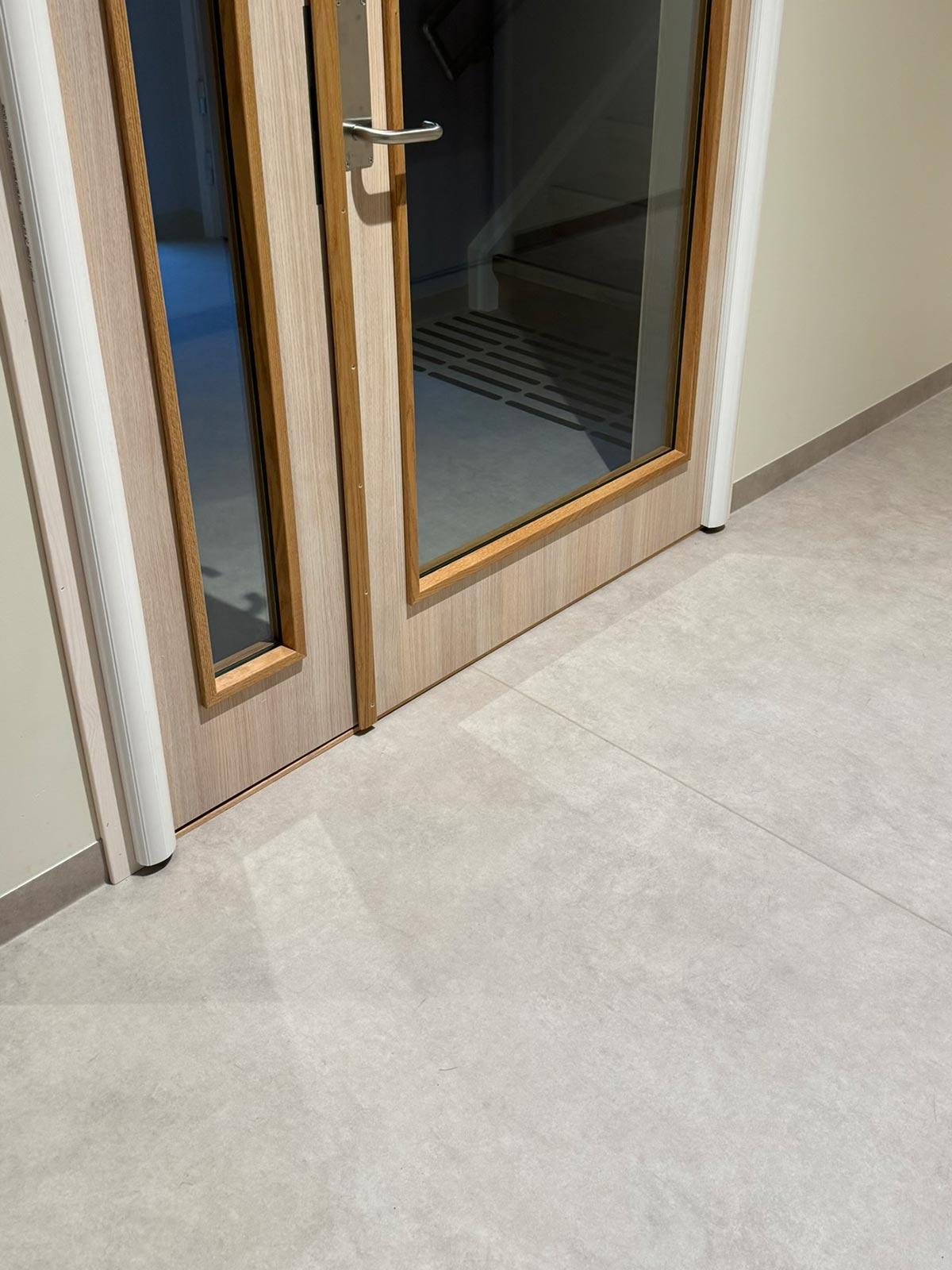 nærbilde av gulv og dør med profil og glass