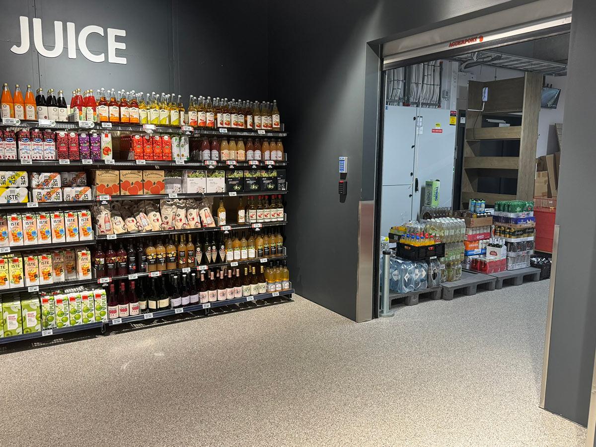 inngang til lageret i en Meny butikk. Hylle med Juice til venstre