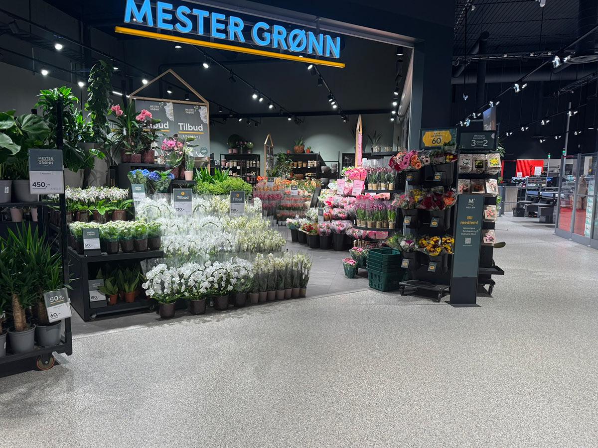 en Mester Grønn butikk hvor man ser hyller med blomster stående utenfor butikken