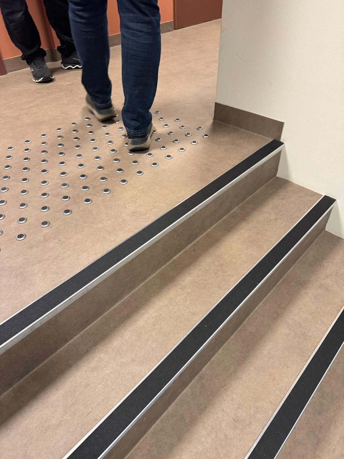 Trapp med sklisikre trinn og taktile indikatorer ved inngangen i Lund Torv studentboliger.